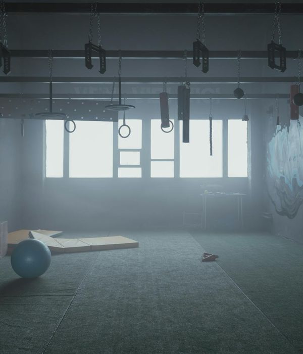 Man performing a functional strength exercise in a dark room with amethyst light.